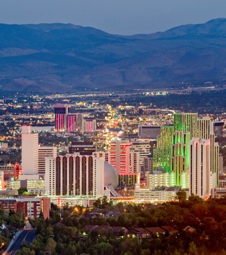 Downtown Reno buildings are illuminated against the night sky